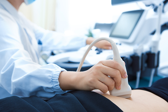 Closeup of an ultrasound exam being performed on an abdomen