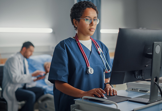 Health care provider typing at a computer before patient undergoes burn surgery.