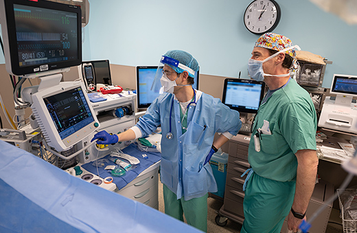 Health care providers looking at screens during burn surgery in operating room.