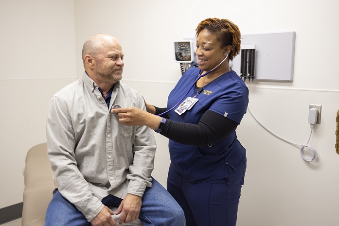 Nurse listening to a man’s heart in the doctor’s office