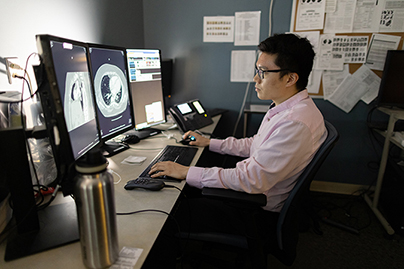 A radiology resident reviewing scans on a computer