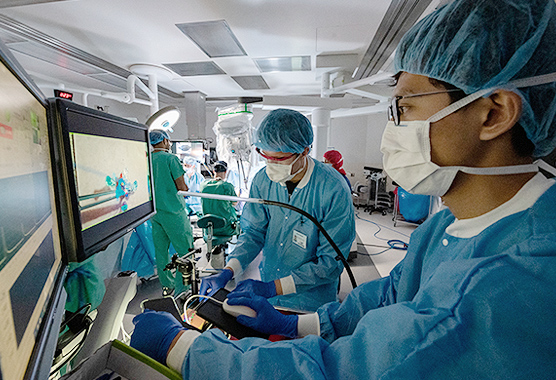 Surgeons performing robotic surgery on a patient.