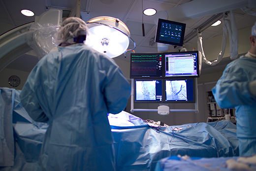 Surgeons working on patient with fluoroscopy screens in front of them