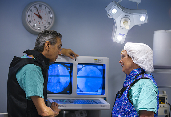 Pain medicine health care providers talking while looking at diagnostic imaging.