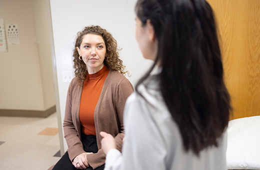 Surgeon discussing minimally invasive surgery with female patient.