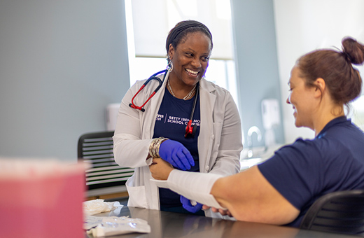 A doctor wraps a fabric splint around a patient’s wrist.
