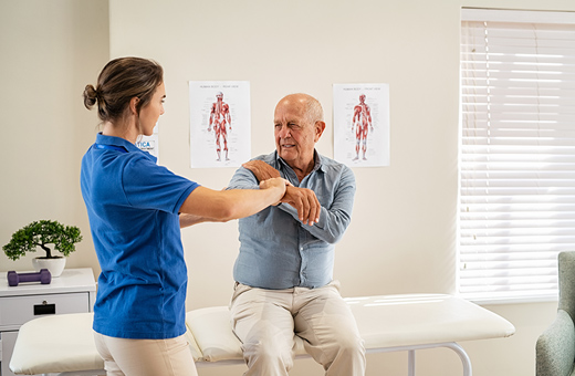 Shoulder surgeon examining patient with shoulder pain. 