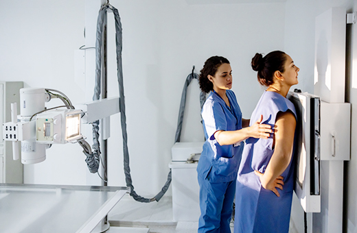 Female provider positioning a patient before an X-ray.