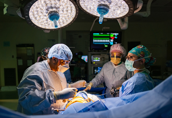 Surgeons performing thoracic surgery on patient.