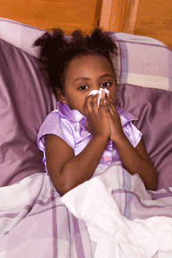 Child in bed with tissue near their nose