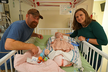 Katie's parents, Kelly and Jeremy Herrmann, with their daughter in the Pediatric and Cardiac Intensive Care Unit at UC Davis Children's Hospital