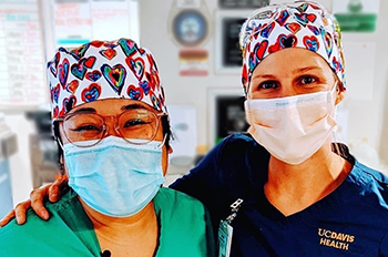 The energetic scrub hats donated from Protect with Heart brought smiles to ICU nurses Kristina Balneg (left) and Jocelyn Spiwak (right).