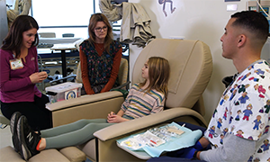 Child life specialist Emily McDaniel and nurse Carter Todd discuss comfort planning with a patient.