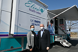 Aidé Long of Elica Health Centers with Sergio Aguilar-Gaxiola of UC Davis Health, in front of the mobile clinic donated by UC Davis Health 