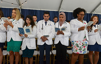 A diverse group of students recite the ethics pledge in 2019 at the most recent in-person induction ceremony