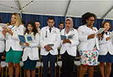 A diverse group of students recite the ethics pledge in 2019 at the most recent in-person induction ceremony