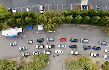 Occupants of vehicles in drive-thru lanes get vaccinated by UC Davis Health and other volunteers at Sleep Train Arena on Saturday.