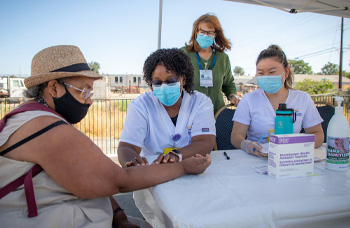  Nursing student Judy Njuguna, center, reads TB test of SETA Head Start employee while her nursing instructor and classmate look on.