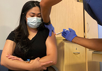 Clinical trial participant Nicholeth Santiago receives her dose of either a Pfizer booster vaccine or placebo
