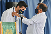 Shervin Zoghi receives his stethoscope from Associate Dean for Students Sharad Jain at induction