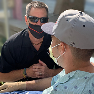 Firefighters Burn Institute Executive Director Joe Pick comforts injured volunteer firefighter Richard Gerety III.