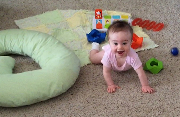 Baby on carpet surrounded by toys