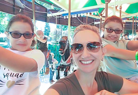 Mother with her two daughters on a merry-go-round