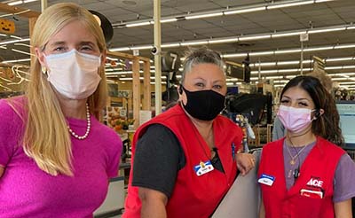 Three people in masks pose at the register at Emigh Ace Hardware in Sacramento