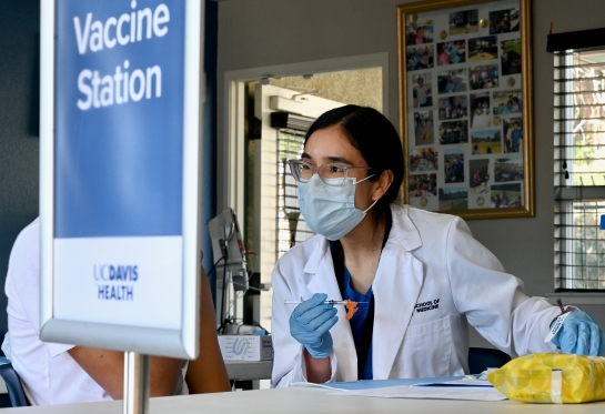 Medical student Alejandra Hernández Villagomez and her professor Ian Kim prepare COVID-19 vaccine doses at a community clinic
