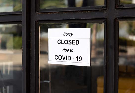 Closed due to COVID-19 sign in front of an office building
