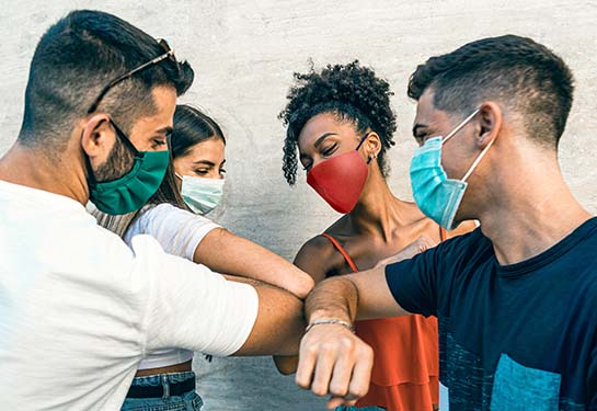 masked people greeting each other with elbow bumps