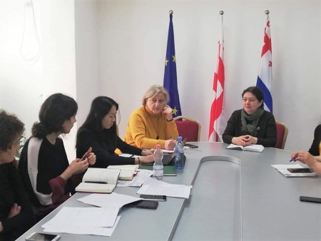 Jade Tso sitting between four people in a meeting of the Adjara Public Health Department in the Republic of Georgia