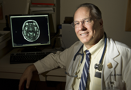 Dr. Charles DeCarli sitting in front of a screen