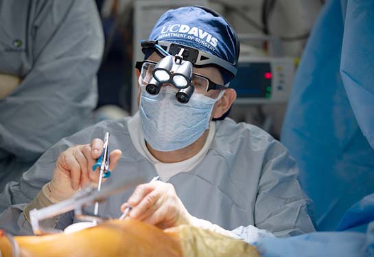 surgeon wearing blue UC Davis hat