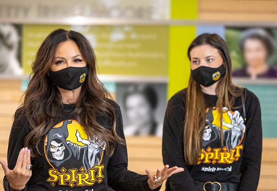 Two women in black Spirit Halloween shirts
