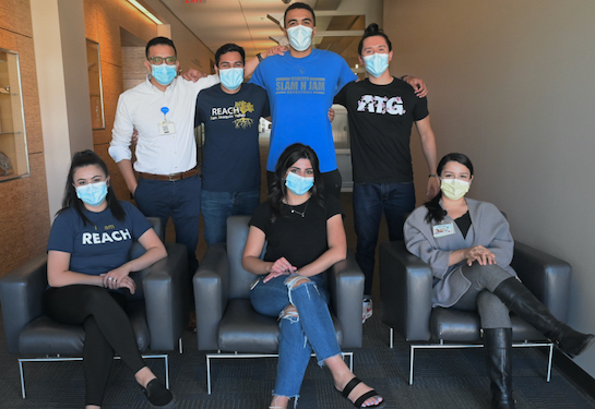 Seven medical students in the REACH pathway pose for picture in face masks inside the UC Davis School of Medicine Education Building