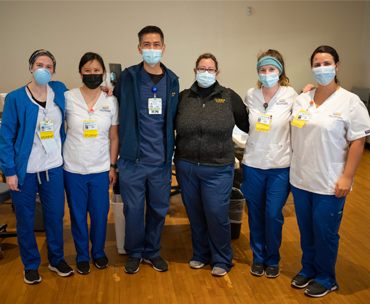 Nursing students stand posing side-by-side