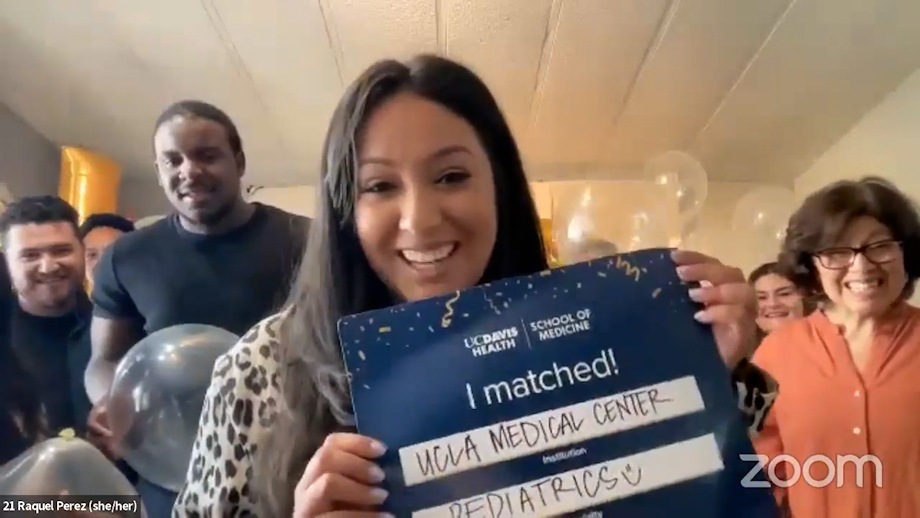 UC Davis Medical student Raquel Perez smiles while holding a blue “I Matched” sign that states she will serve her pediatrics residency at UCLA Medical Center