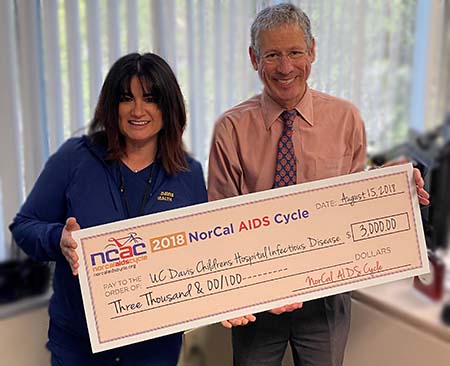 Tami Emslie and Dean Blumberg hold check