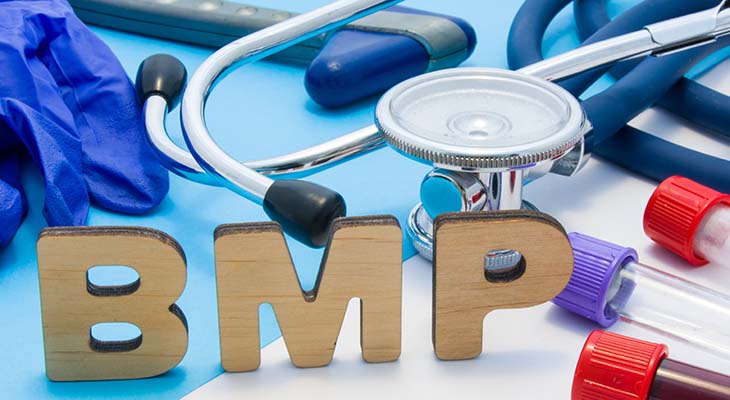 Letters that make word of BMP, located near test tubes with blood, stethoscope and other diagnostic tools and devices, latex gloves