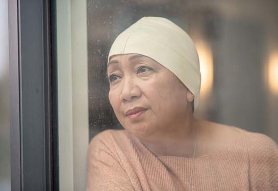 Female cancer patient looking out window