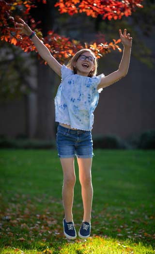 Young female jumping outside on the grass