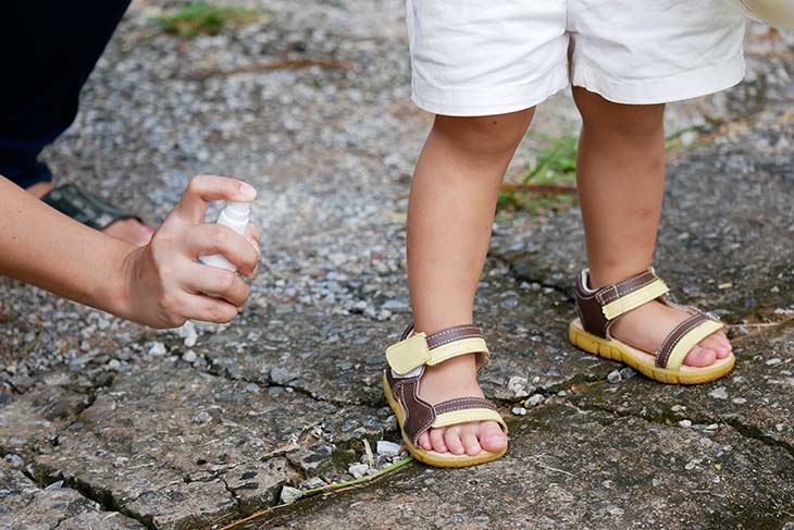 Child being sprayed with repellent