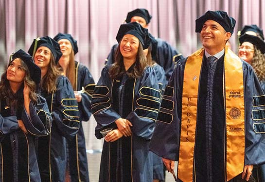 Medical students wearing blue graduation robes.