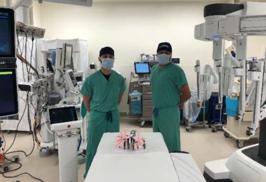 Doctors Phan and Godoy wearing green scrubs and mask standing in operating room