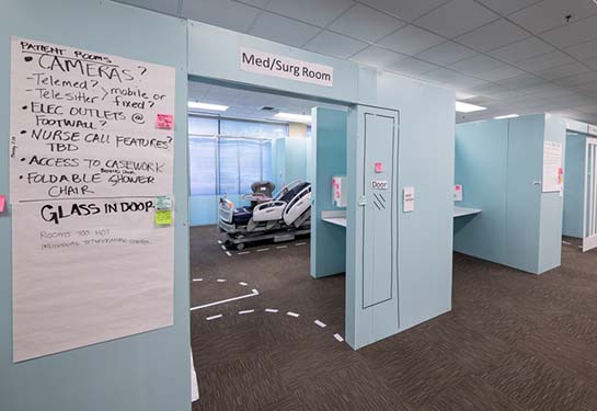 Row of mock-up patient rooms with notes on them