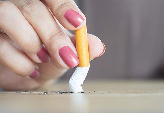 Female hand crushing cigarette
