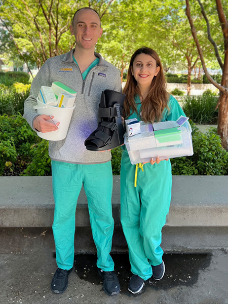 Medical students Carter White and Aida Nasirishargh display an orthopedic boot and other surplus items they collect and donate