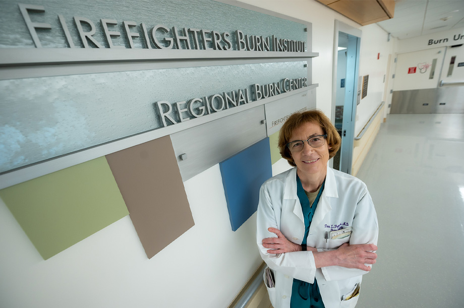 Tina Palmieri, a UC Davis Health burn surgeon, wears white coat and stands in front of burn center sign