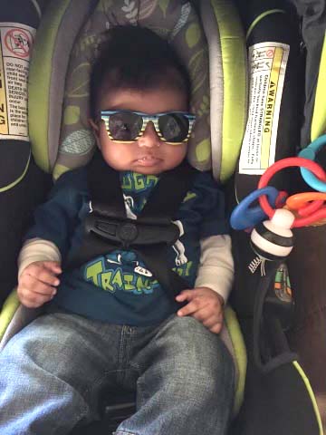 Isaac Franco in a car seat with sunglasses over his eyes